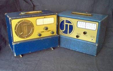 Two small portable radios with  slide rule dials, 2 or 3 small knobs and round speaker grill on left front.